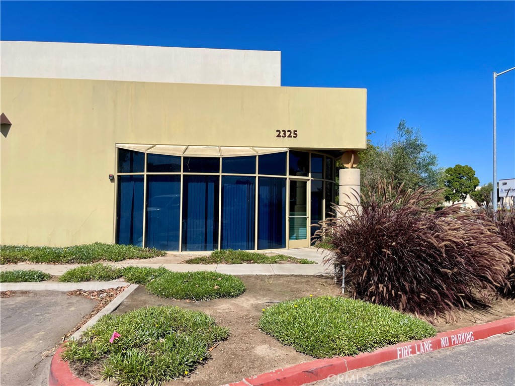 Commercial building marked 2325, with a glass storefront and landscaped frontage.