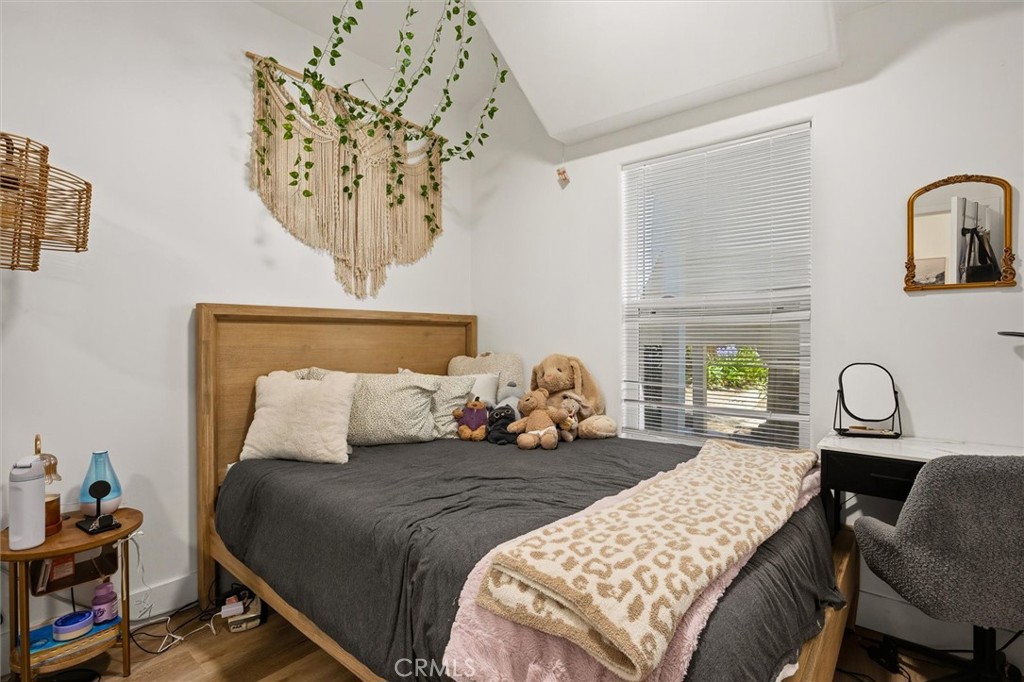 Bedroom with a wooden bed, plush toys, and a woven wall hanging above the headboard.