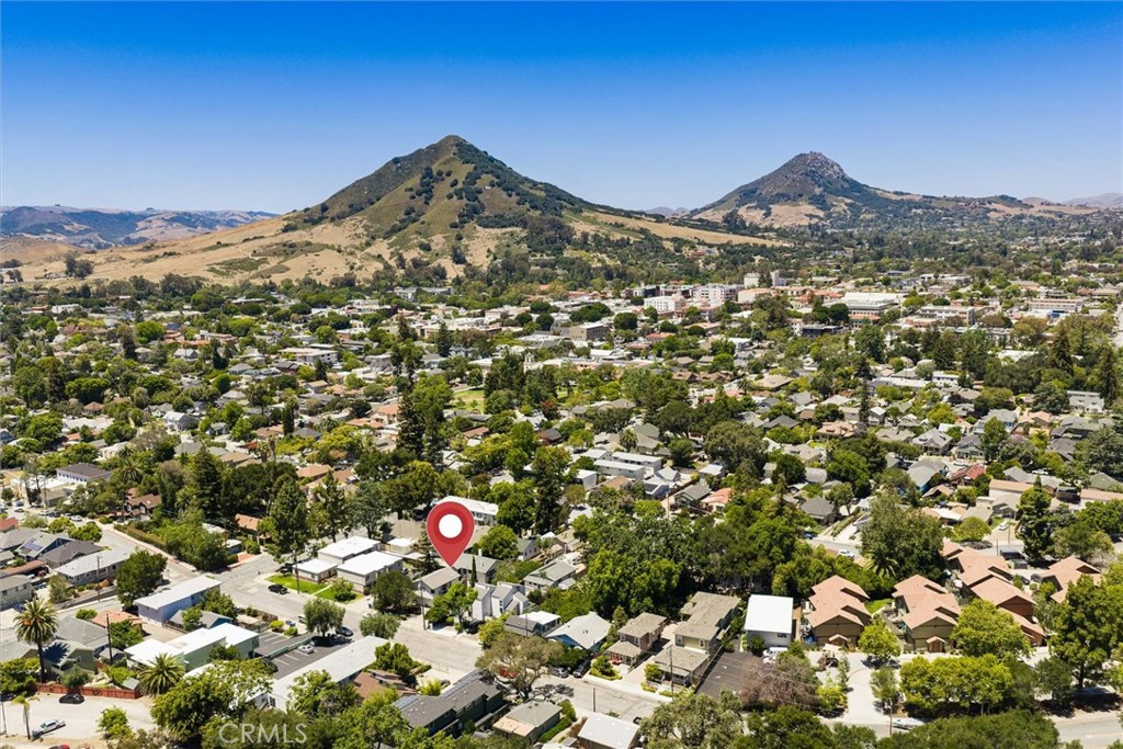 Aerial view of the property and surrounding neighborhood, with hills beyond.