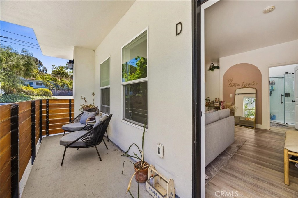 Furnished balcony beside an open doorway to a living room with an arched accent wall.
