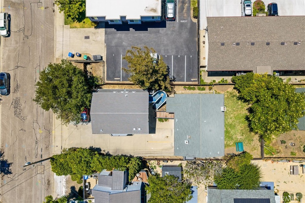 Aerial view of the property and surrounding buildings, trees, yard, and parking lot.