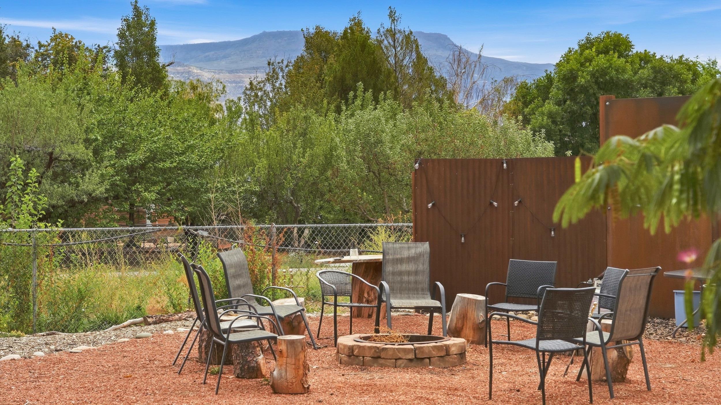 Outdoor patio with a stone fire pit, metal seating, and mountain views