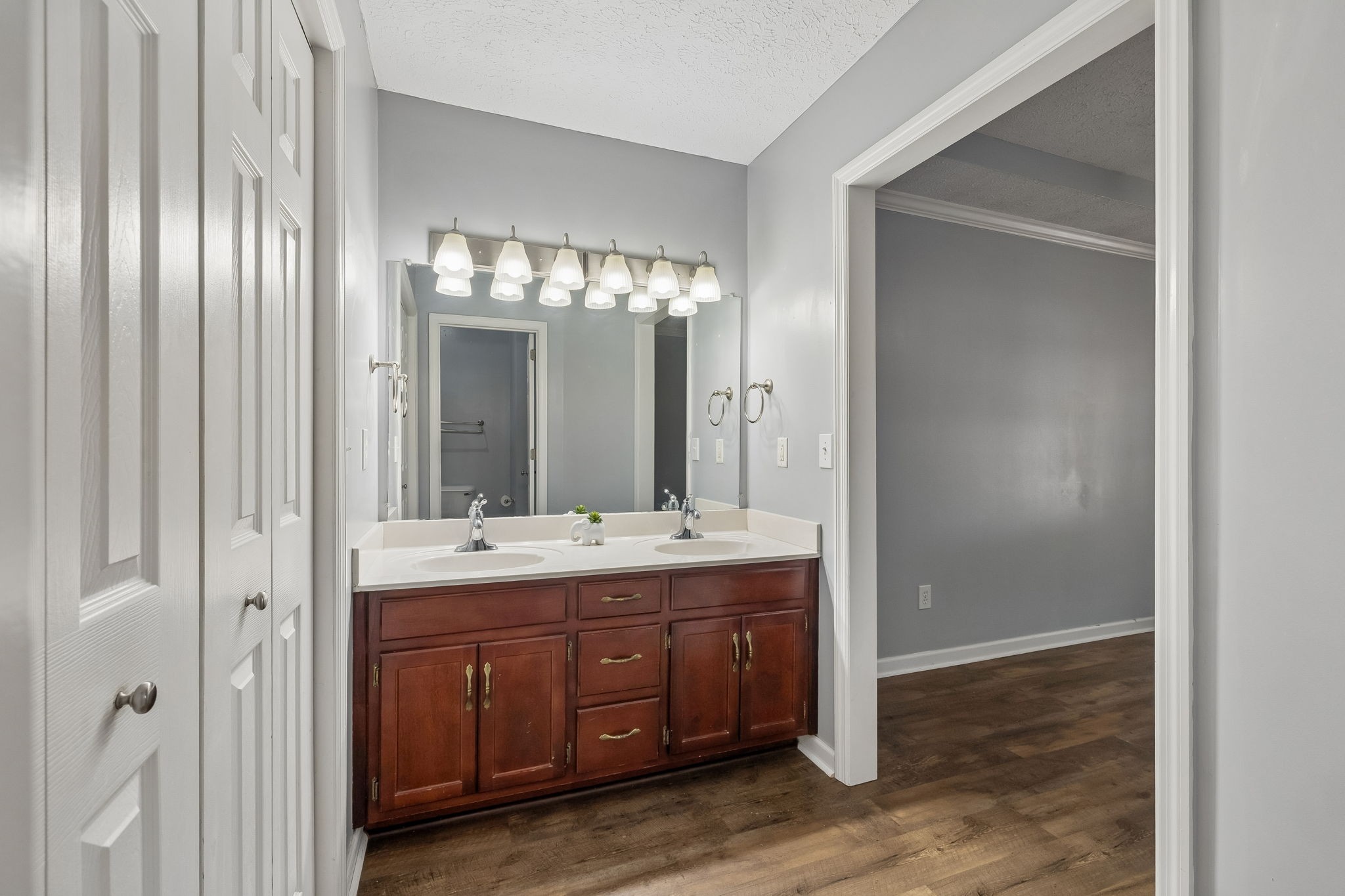 Bathroom with a dark wood double vanity, two sinks, and a wide mirror.