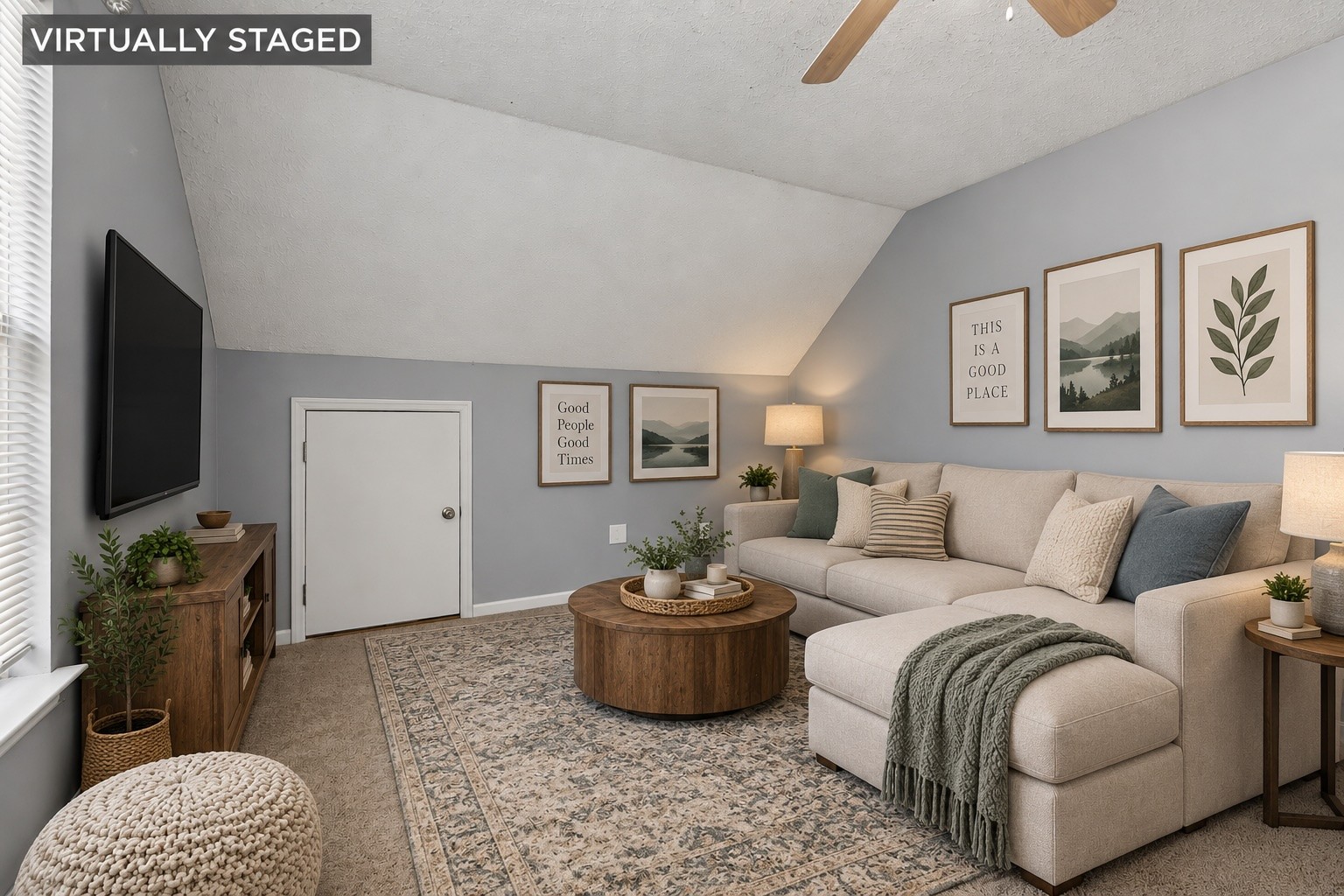 Virtually staged living room with a vaulted ceiling, beige sectional sofa, and round wood coffee table.