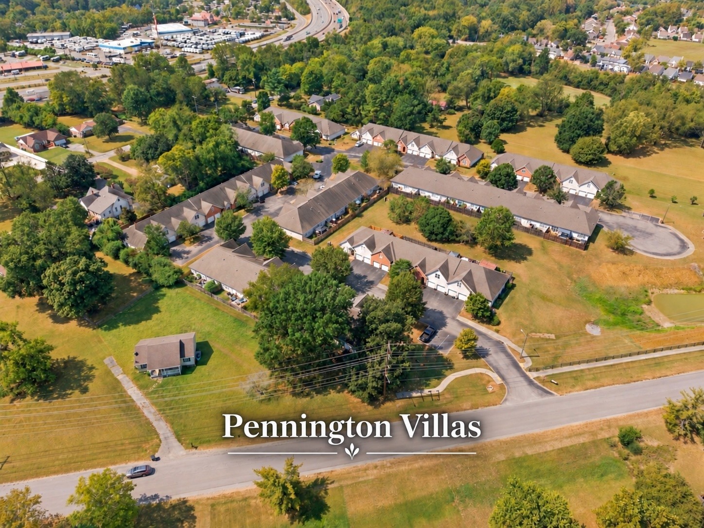 Aerial view of Pennington Villas, showing rows of attached homes, green lawns, and mature trees.