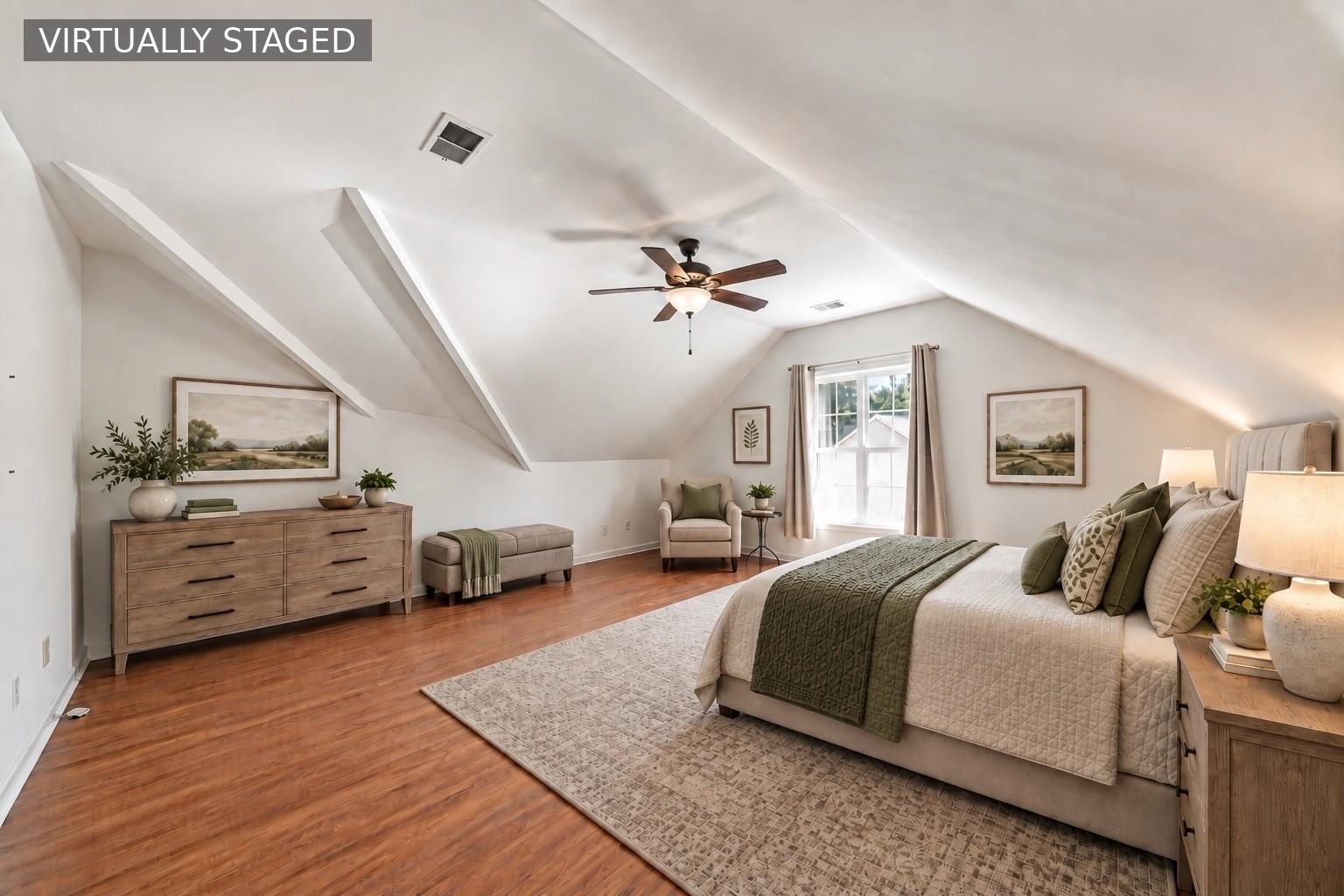 Virtually staged bedroom with a large bed, hardwood floors, and a high sloped ceiling.
