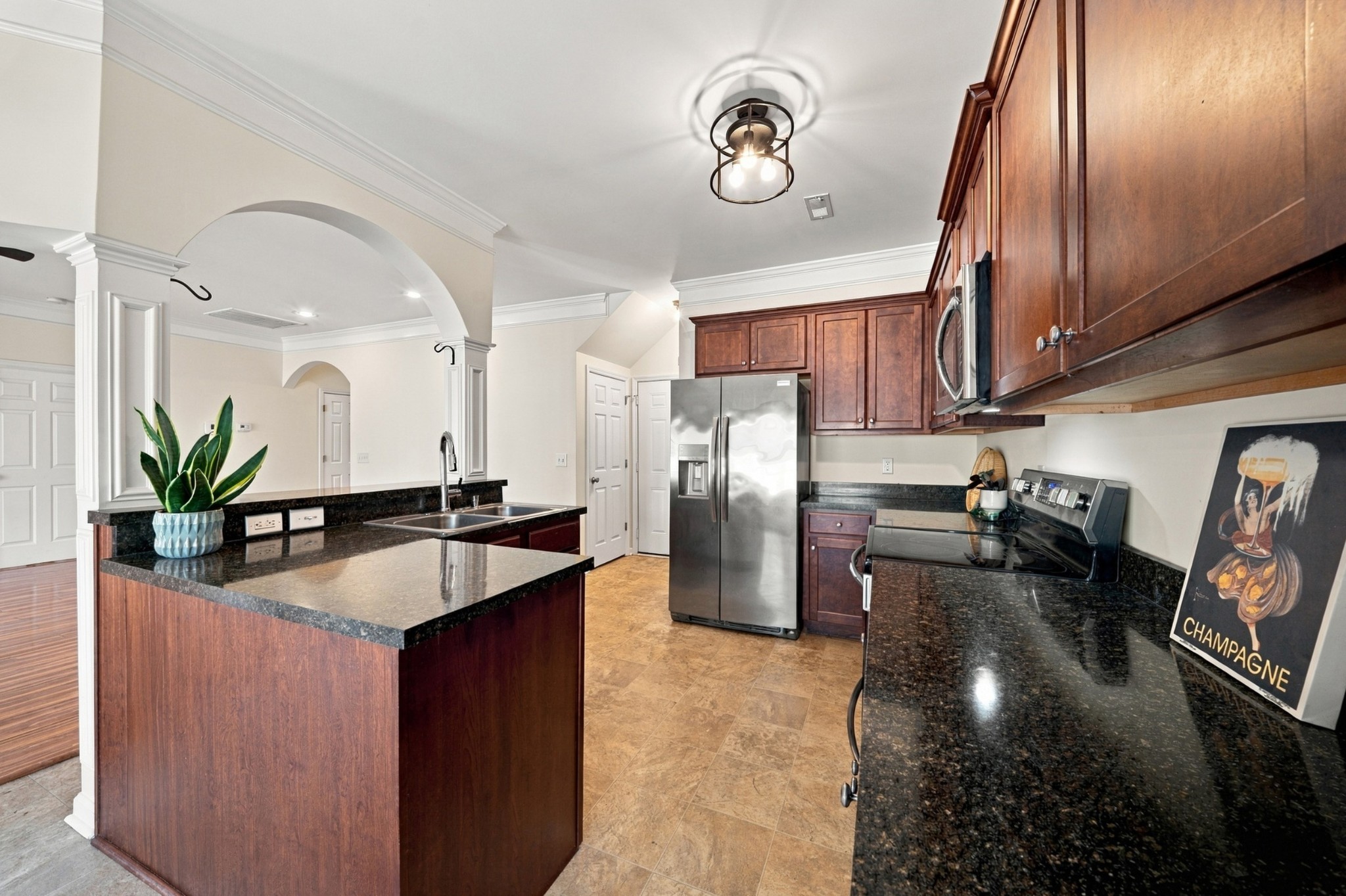 Kitchen with dark wood cabinetry, granite counters, a central island, and stainless steel appliances.