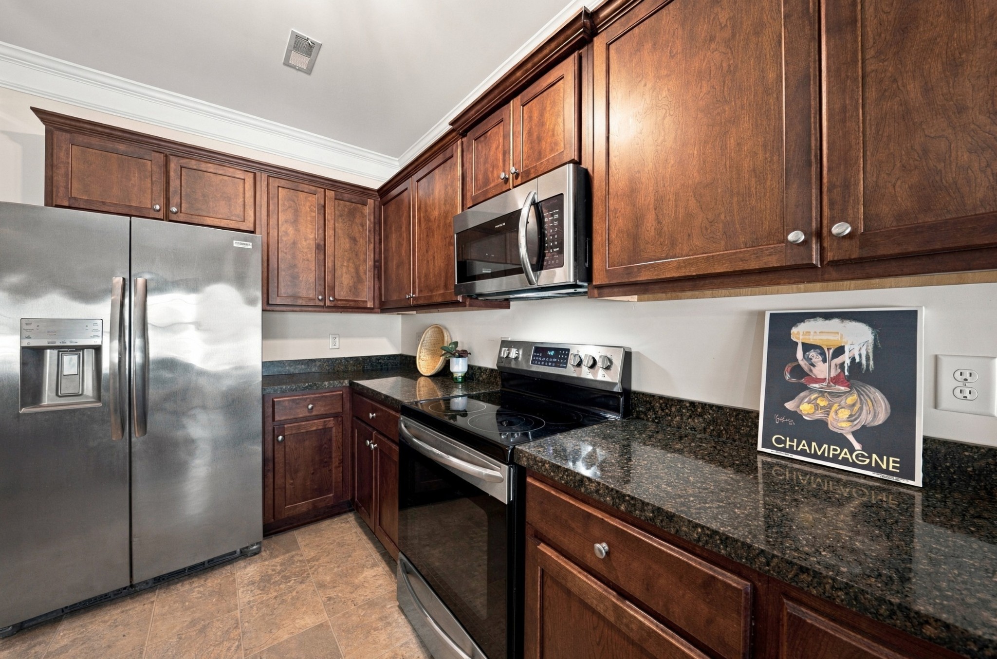 Kitchen with dark wood cabinetry, granite counters, and stainless steel appliances.