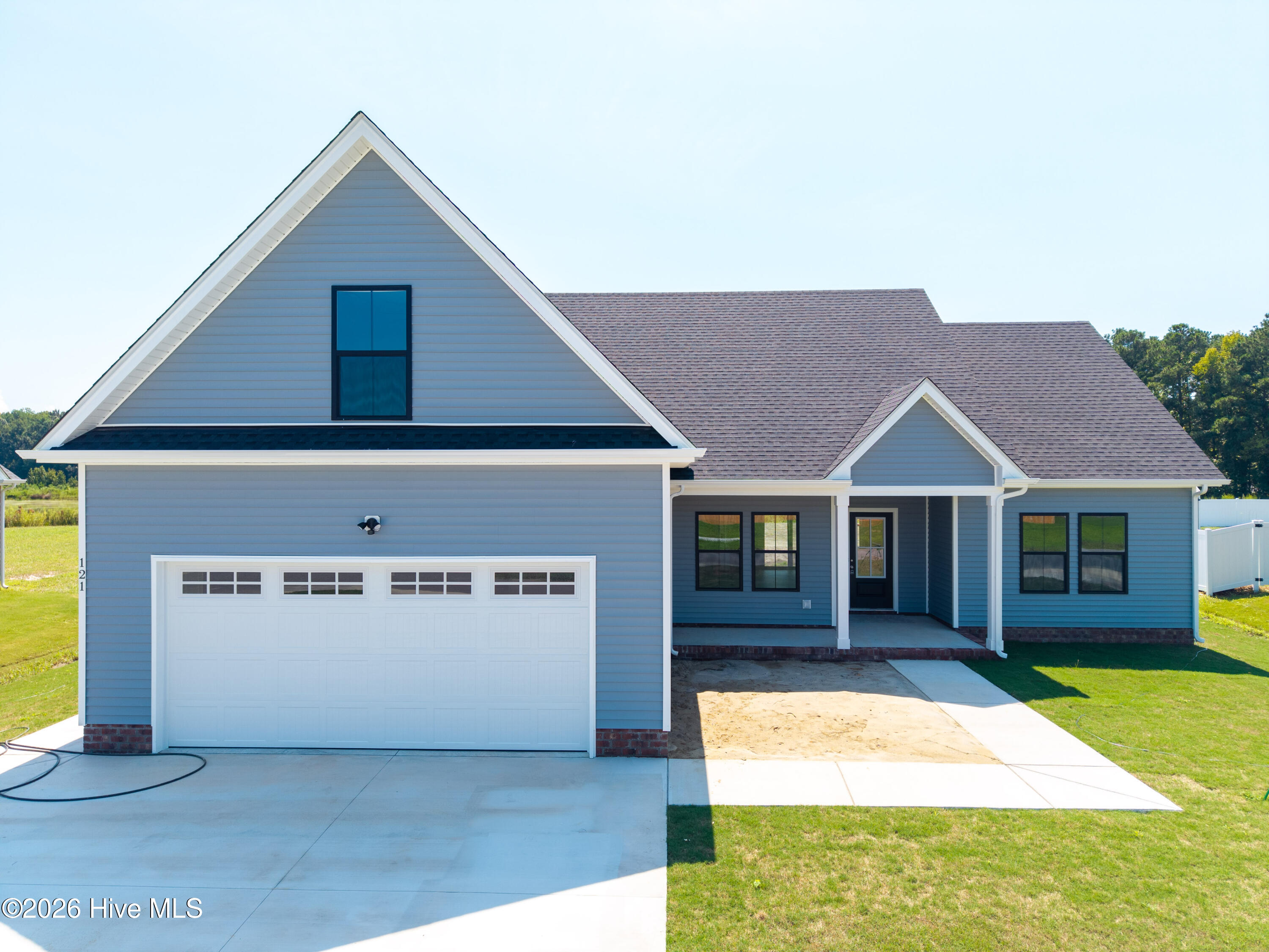 Blue-sided house with a steep front gable, white two-car garage, and covered entry.