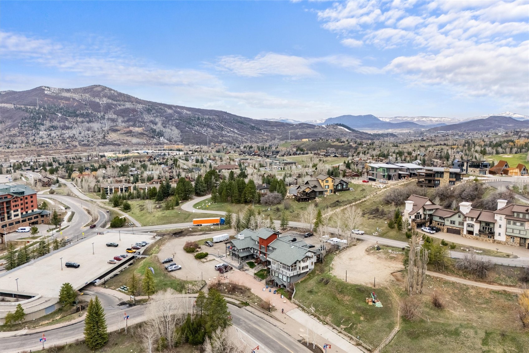 Aerial view of a residential building with the mountain valley and surrounding homes beyond.