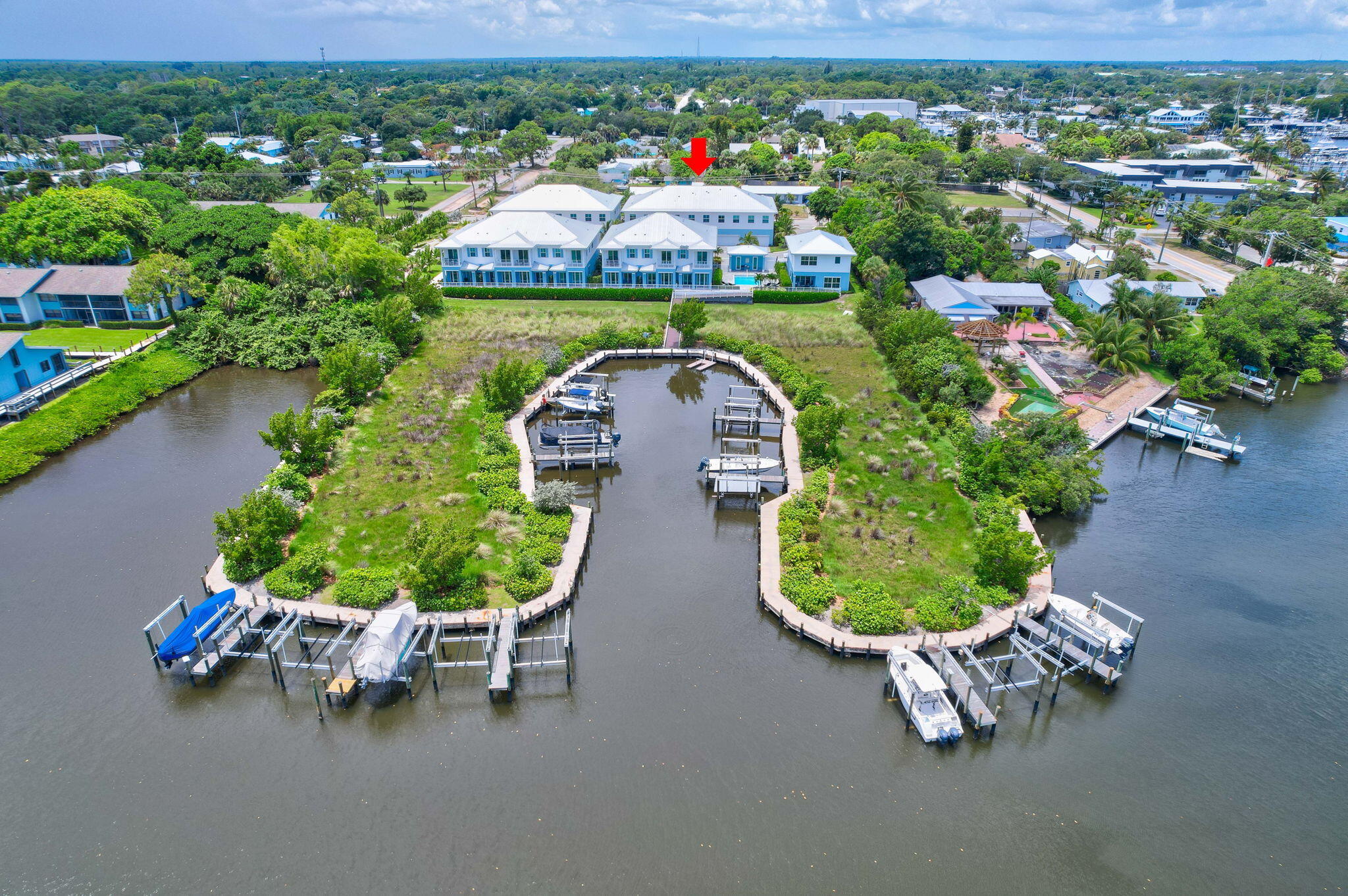 Waterfront property beside a canal basin, marked by a red arrow, with multiple boat docks.