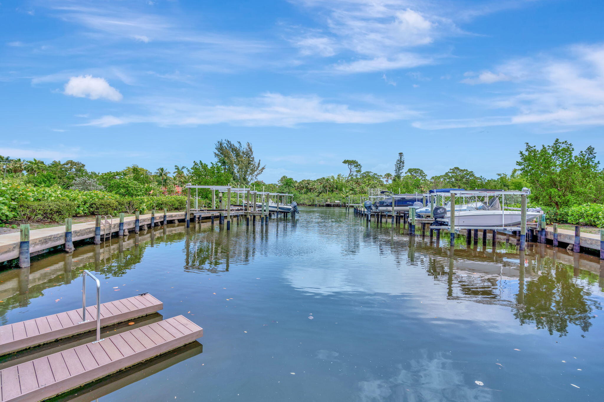 Canal lined with boat docks and lifts, with a small dock in the foreground.