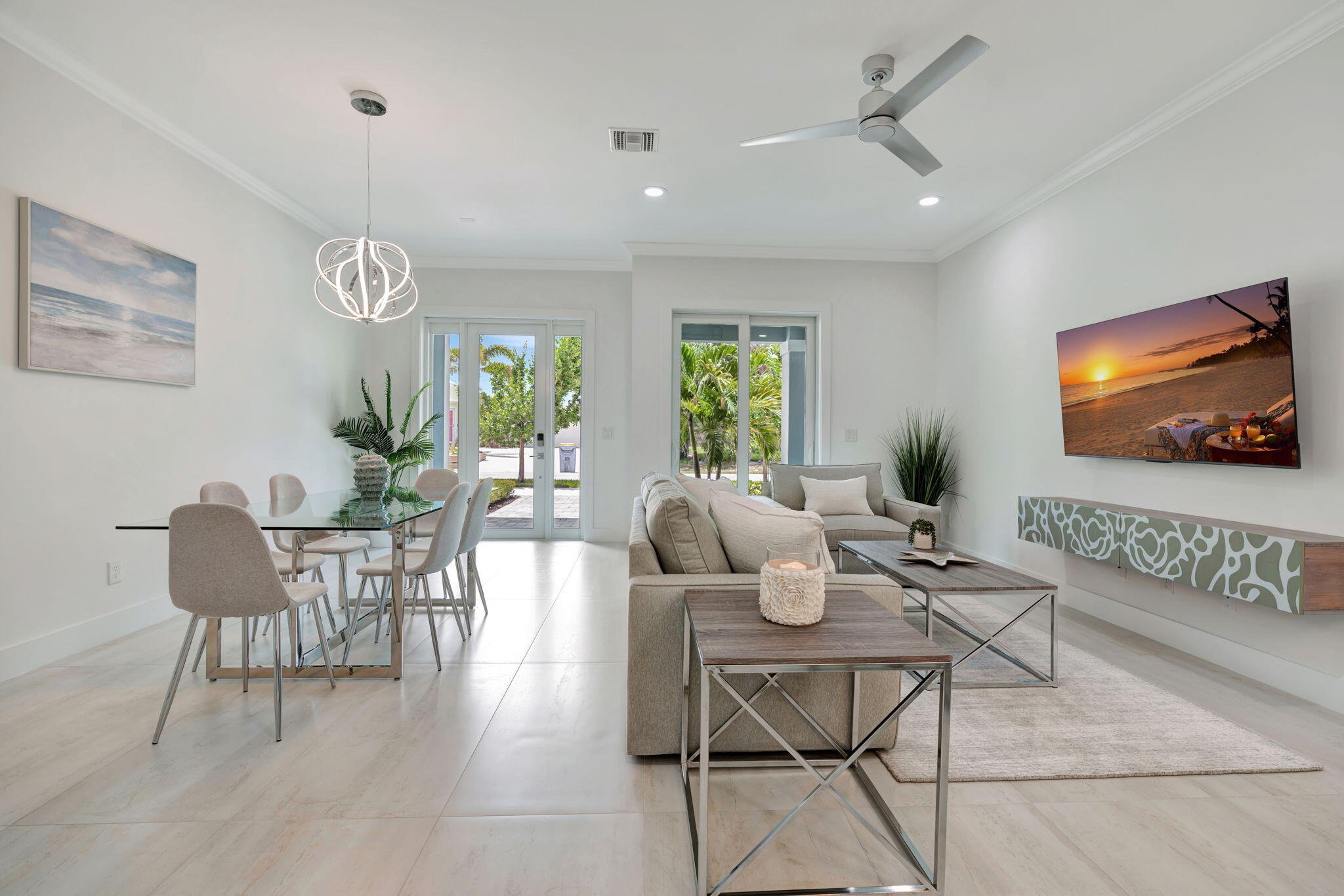 Open-plan living and dining room with neutral furnishings and sliding doors overlooking greenery.