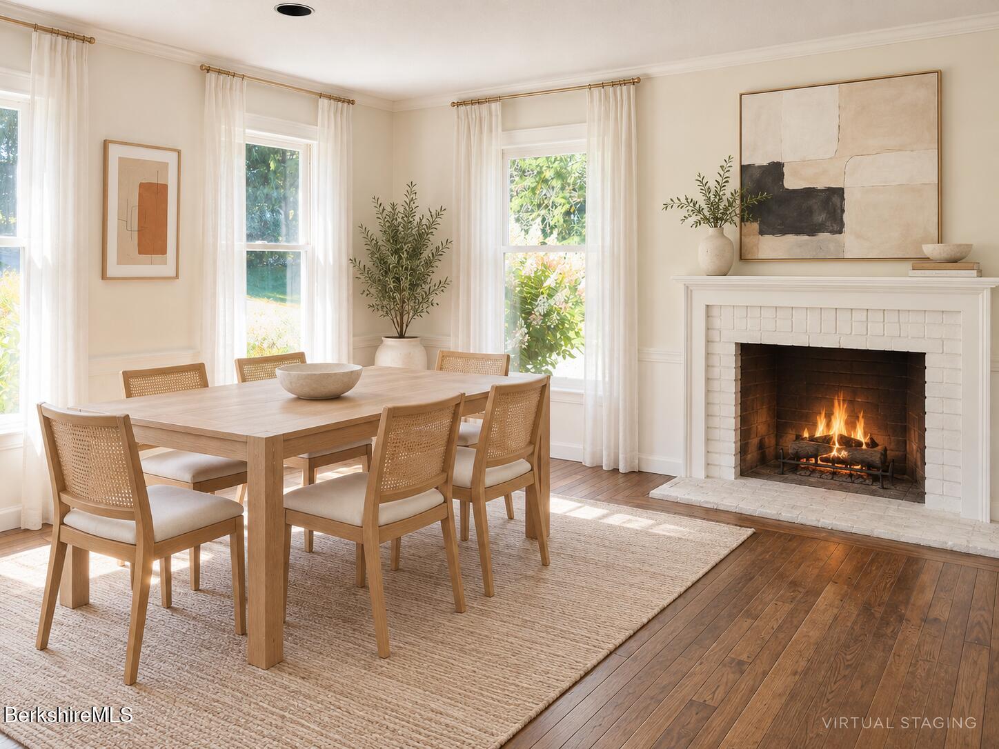 Virtually staged dining room with a wood table, sunlit windows, and a lit white brick fireplace.