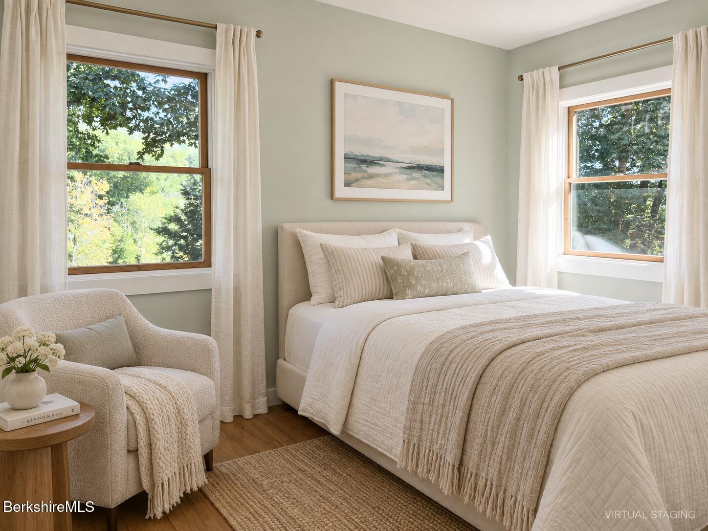 Virtually staged bedroom with a cream bed, armchair, and two windows overlooking leafy greenery.