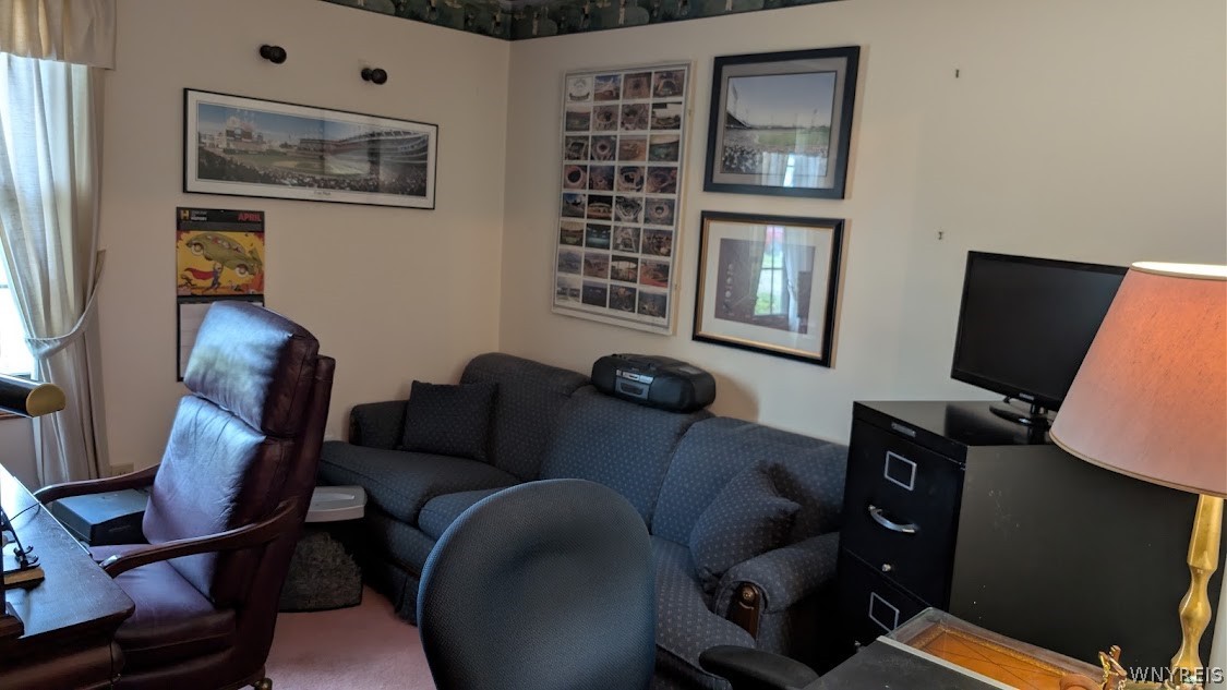 Furnished living room with a blue sofa, leather recliner, framed wall art, and television.
