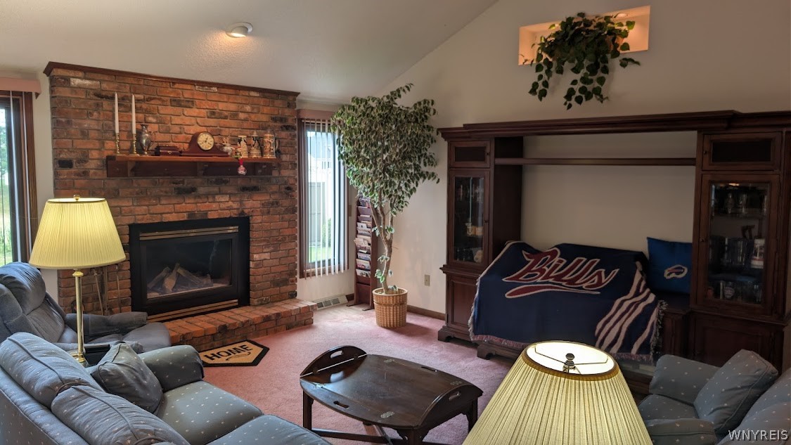 Living room with a brick fireplace, blue sofas, and a Buffalo Bills blanket.