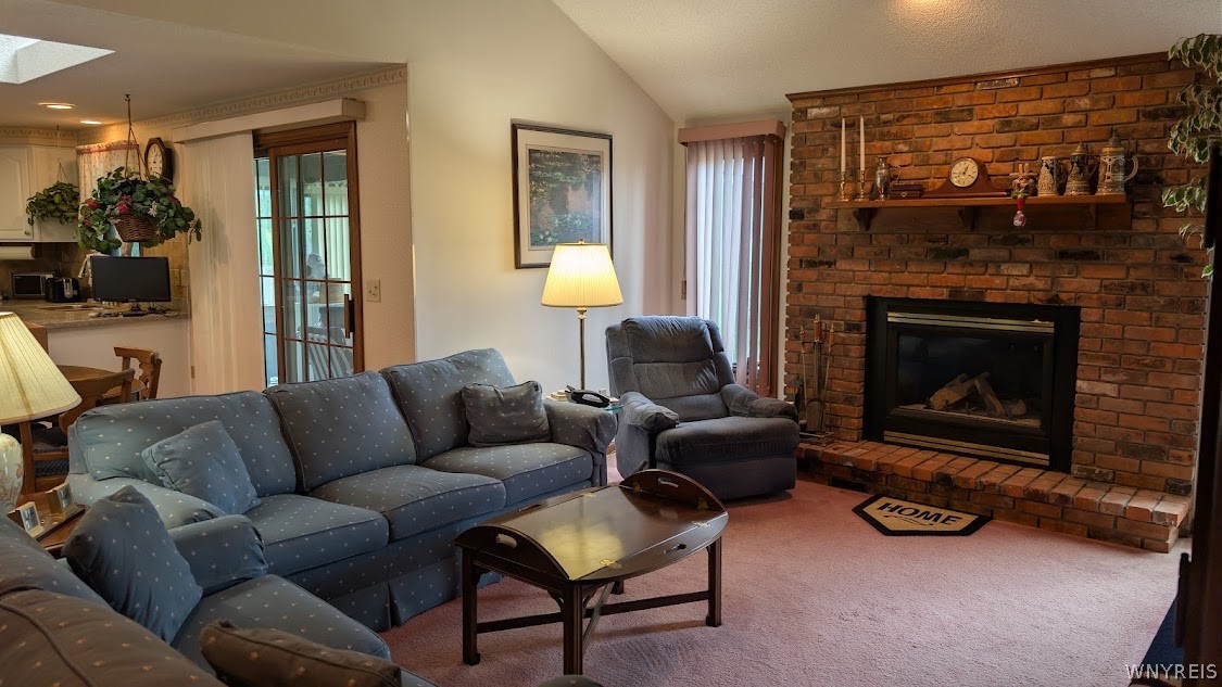 Furnished living room with a blue sectional and brick fireplace.