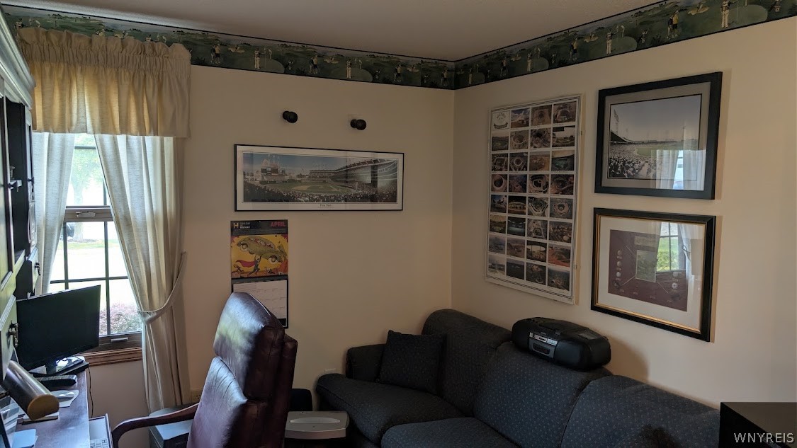 Living room with a dark sectional sofa, leather recliner, and framed wall art.