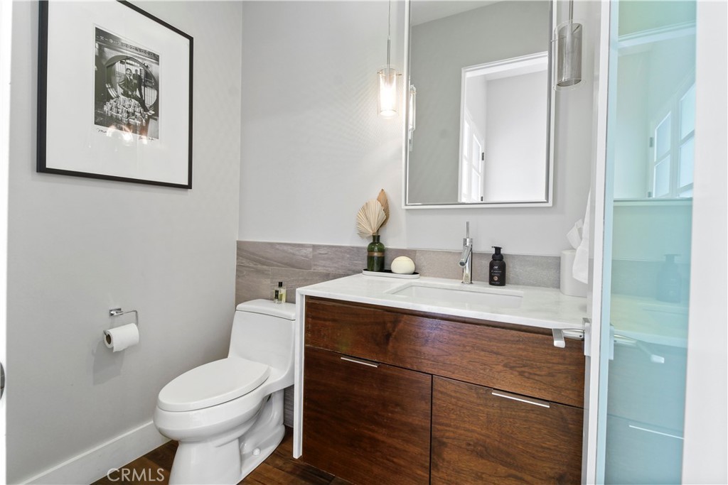 Modern bathroom with a dark wood vanity, white sink, and glass shower enclosure.