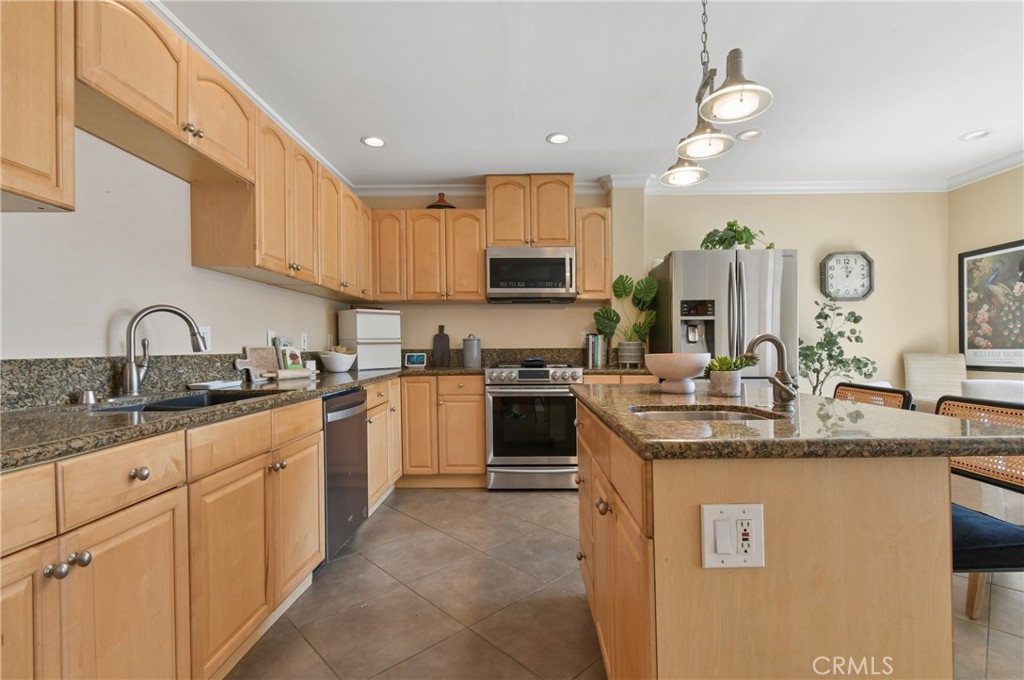 Kitchen with wood cabinets, granite counters, a central island, and stainless steel appliances.