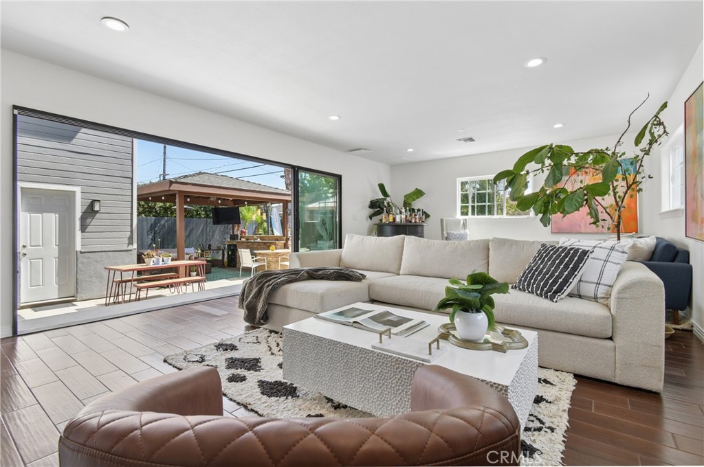 Furnished living room with a cream sectional and sliding doors opening to a covered patio.