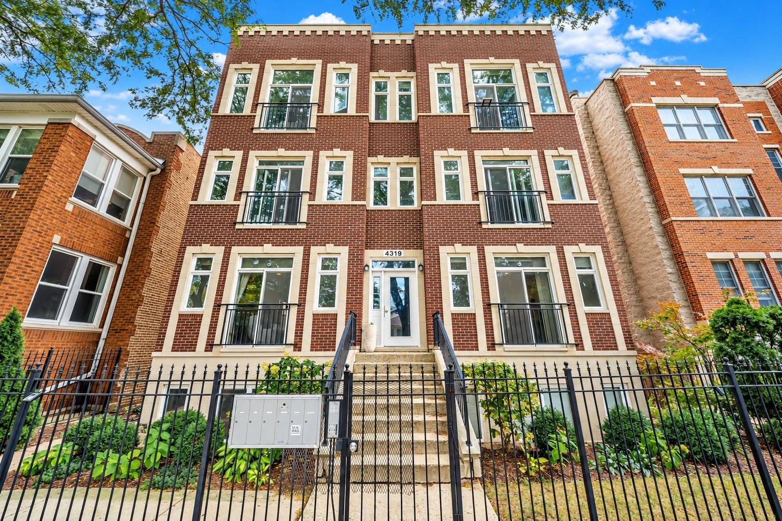 Brick apartment building with cream trim, balconies, and a gated entrance at 4319 N Richmond Street.
