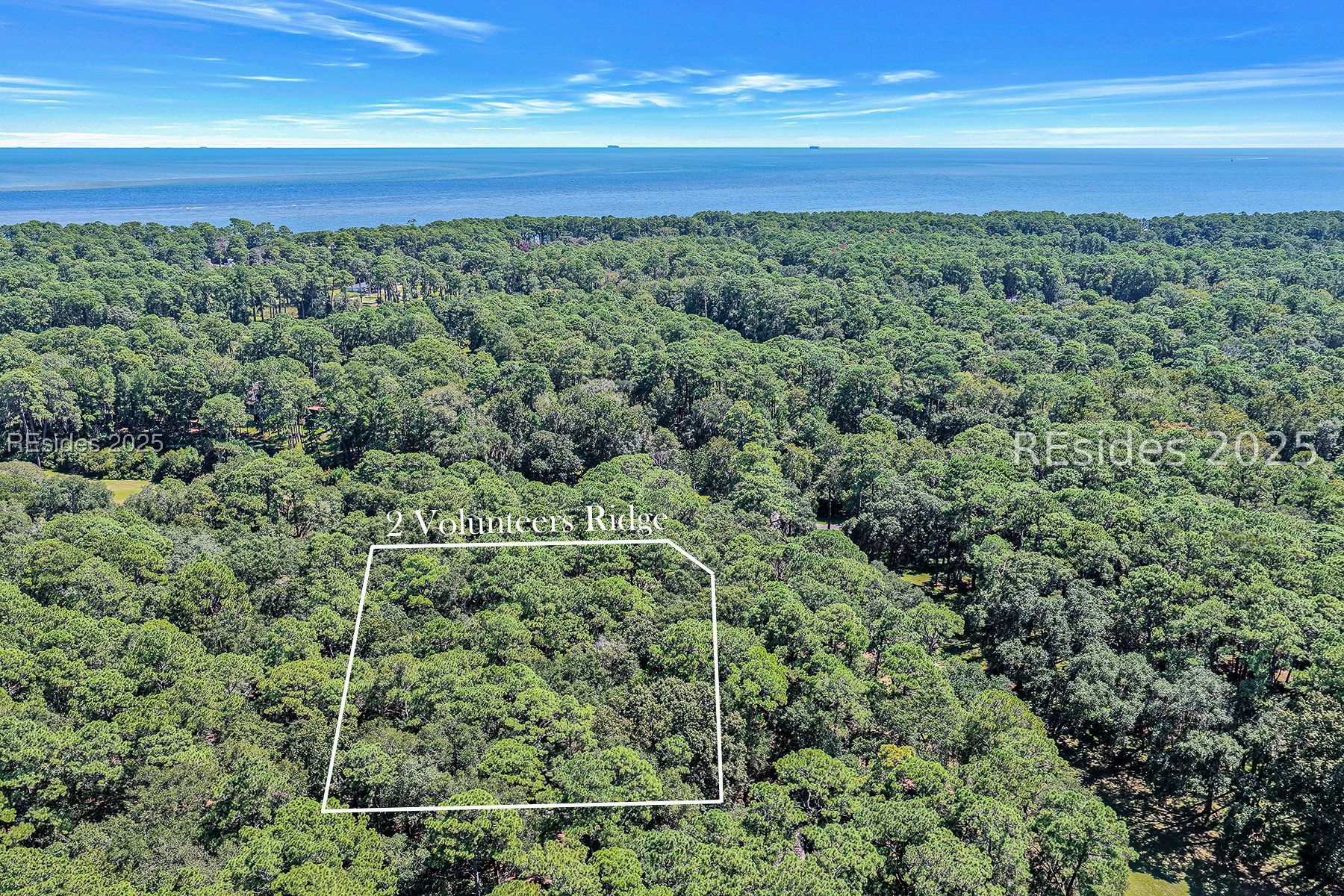Aerial view of the wooded 2 Volunteers Ridge lot outlined near the Atlantic coast.