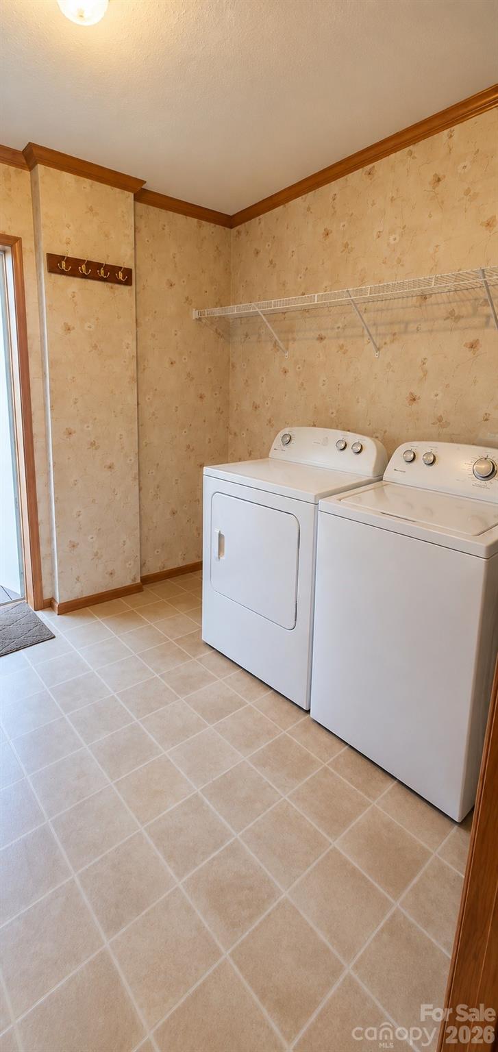 Laundry room with side-by-side washer and dryer beneath a wire shelf.