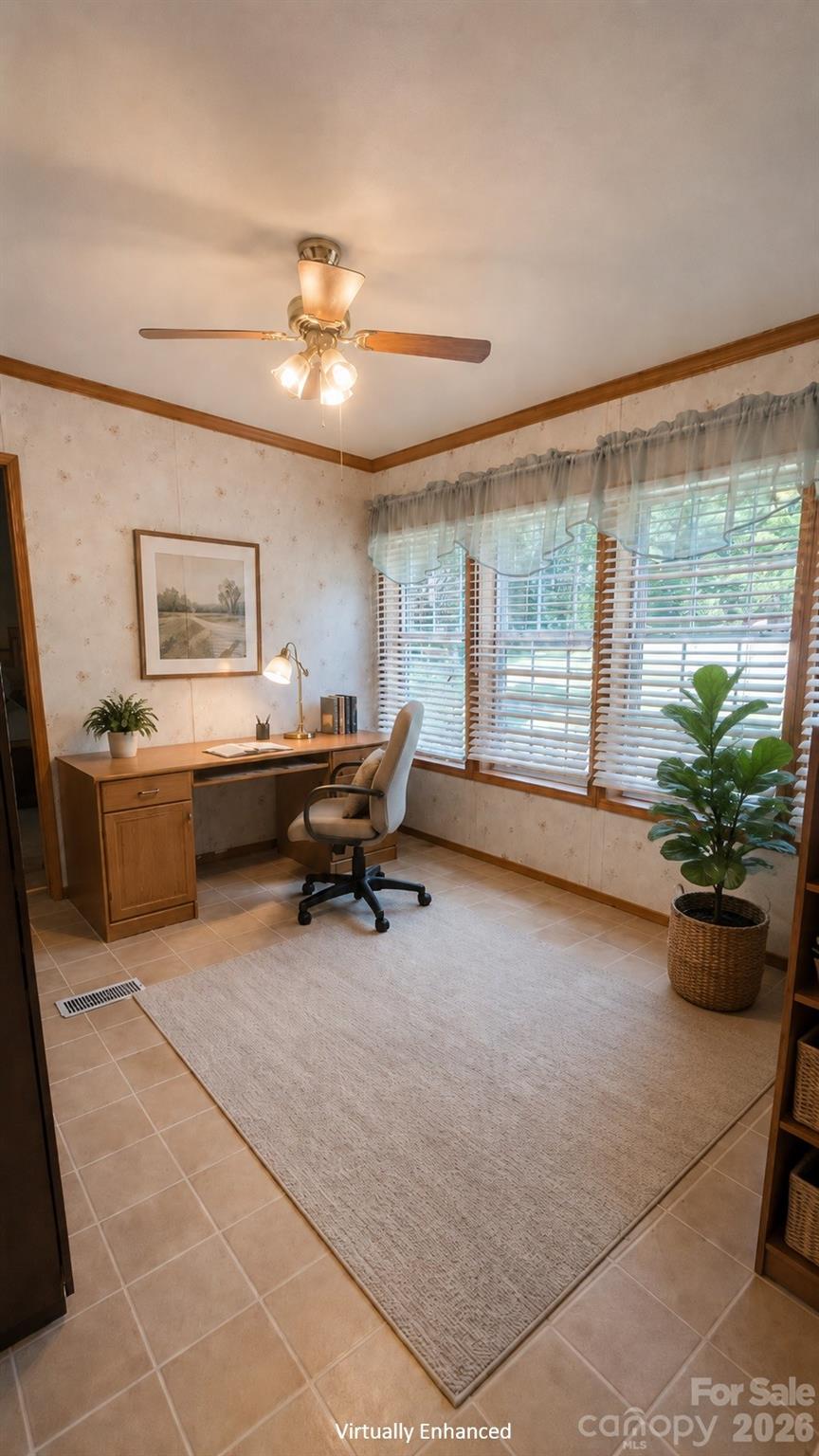 Furnished home office with a wooden desk, window blinds, ceiling fan, and potted plants.