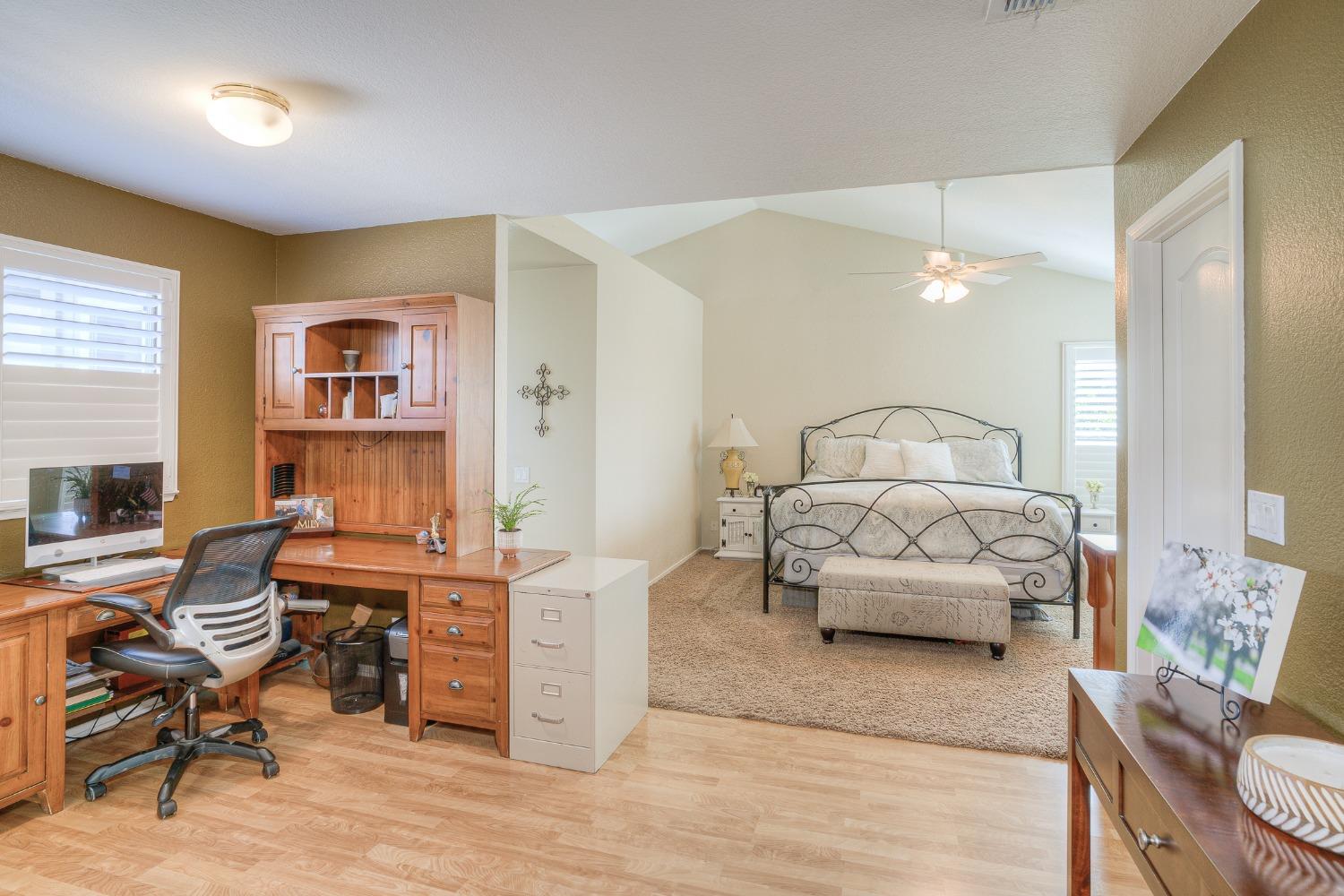 Bedroom with a black metal bed and an adjoining desk workspace.