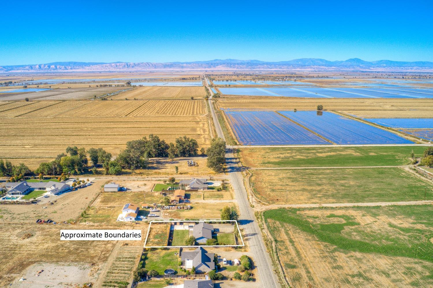 Aerial view of a rural property outlined beside a road, surrounded by agricultural fields.