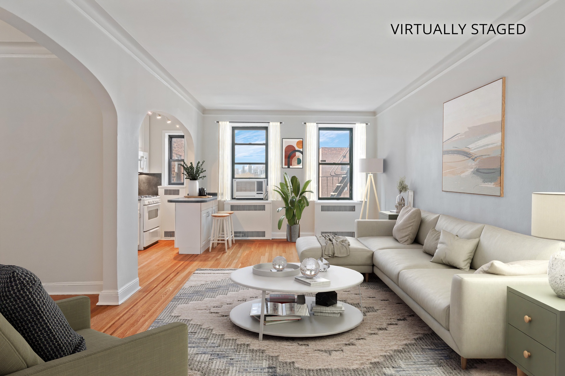 Virtually staged living room with an open kitchen, hardwood floors, and a large sectional sofa.