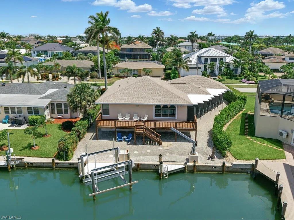 Waterfront home with a raised deck and private dock along a Marco Island canal.