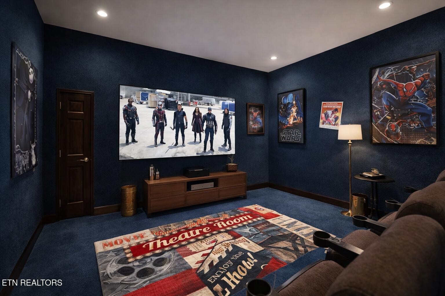 Home theater with blue walls, reclining seats, a large screen, and superhero posters.