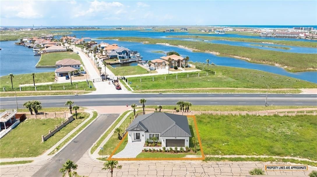 Modern home on an orange-outlined lot beside coastal waterways and a residential neighborhood.