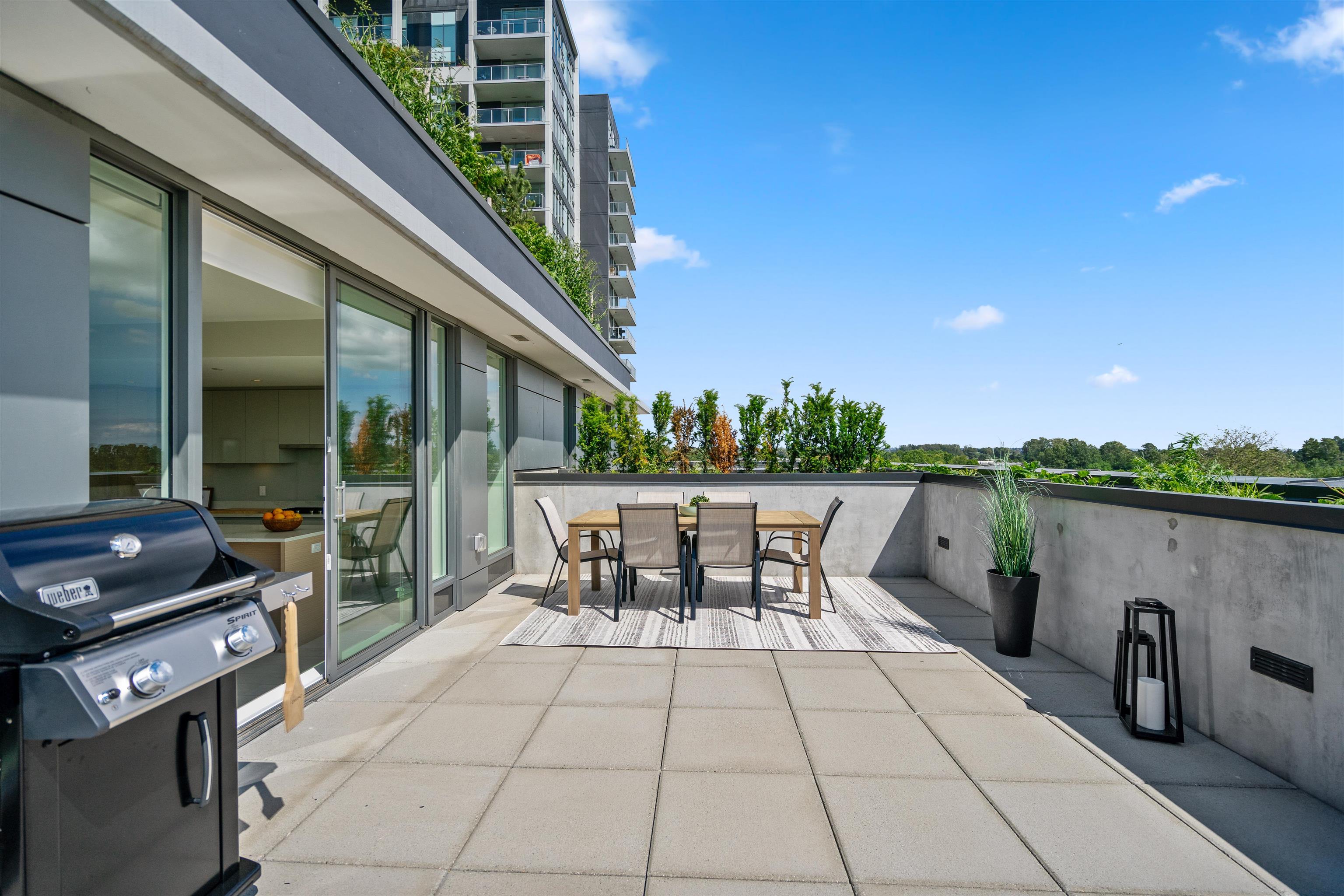 Apartment terrace with outdoor dining set, gas barbecue, and sliding glass doors.