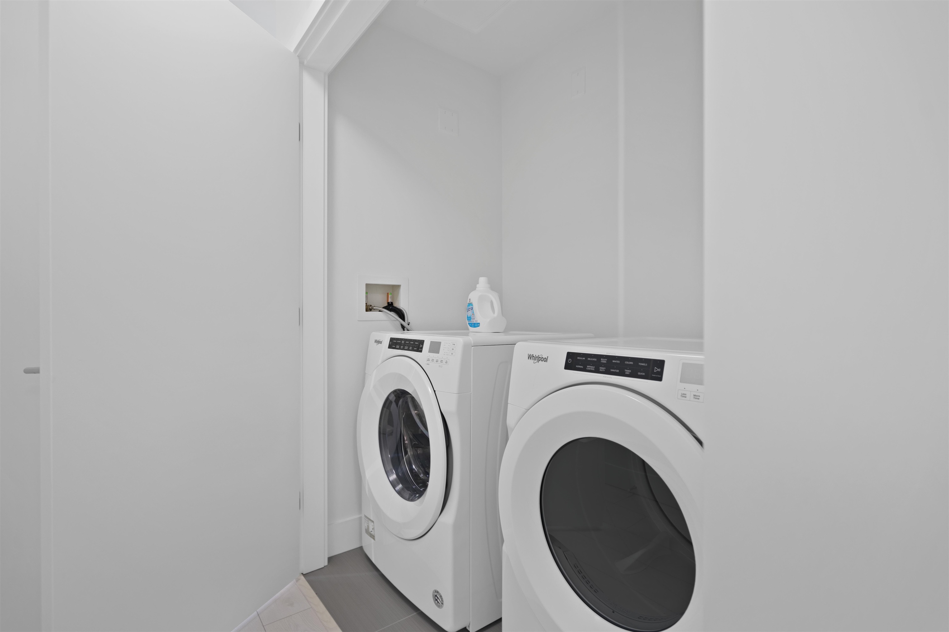 Laundry room with side-by-side front-loading washer and dryer.