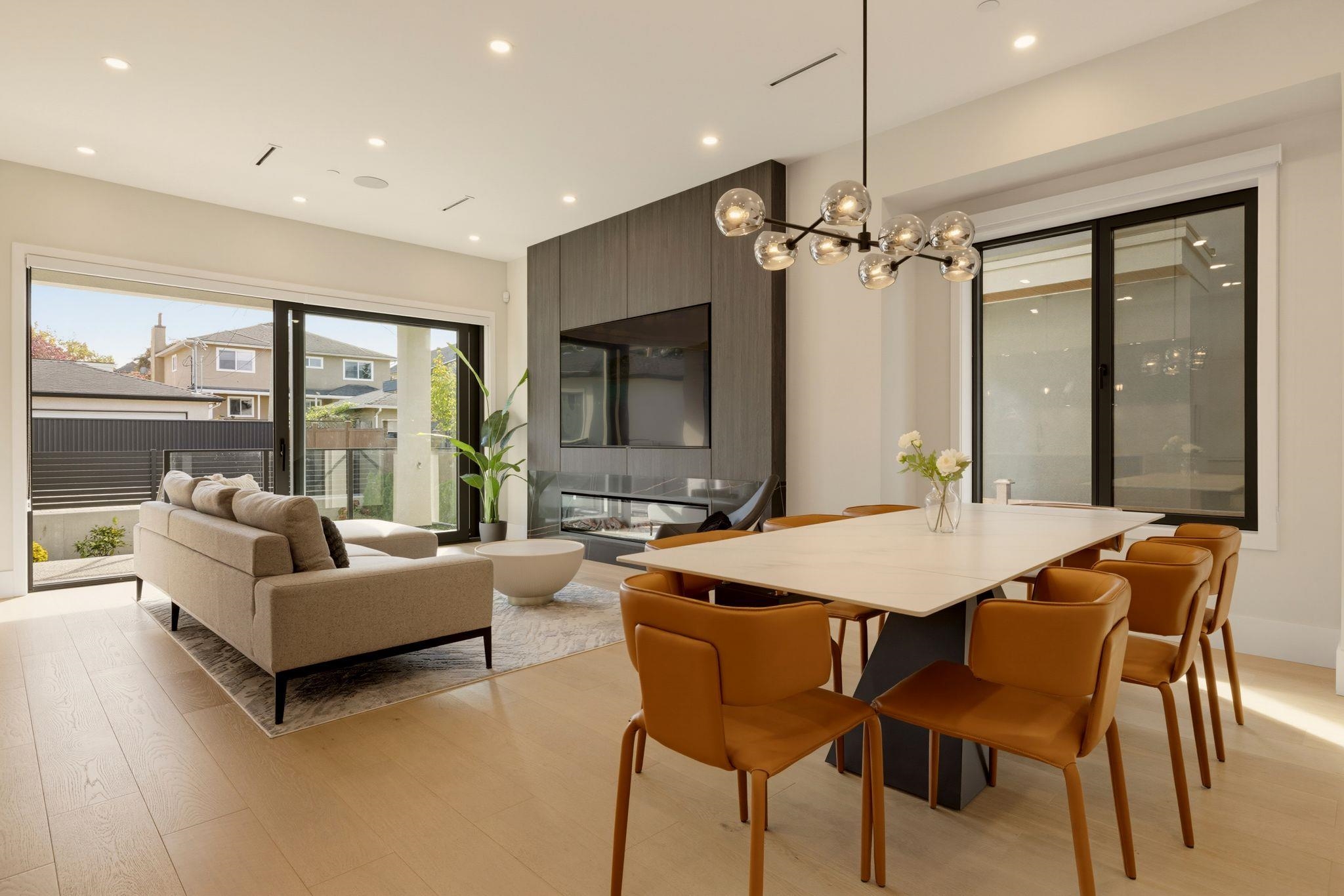 Open-plan living and dining room with a built-in fireplace and sliding doors to a patio.