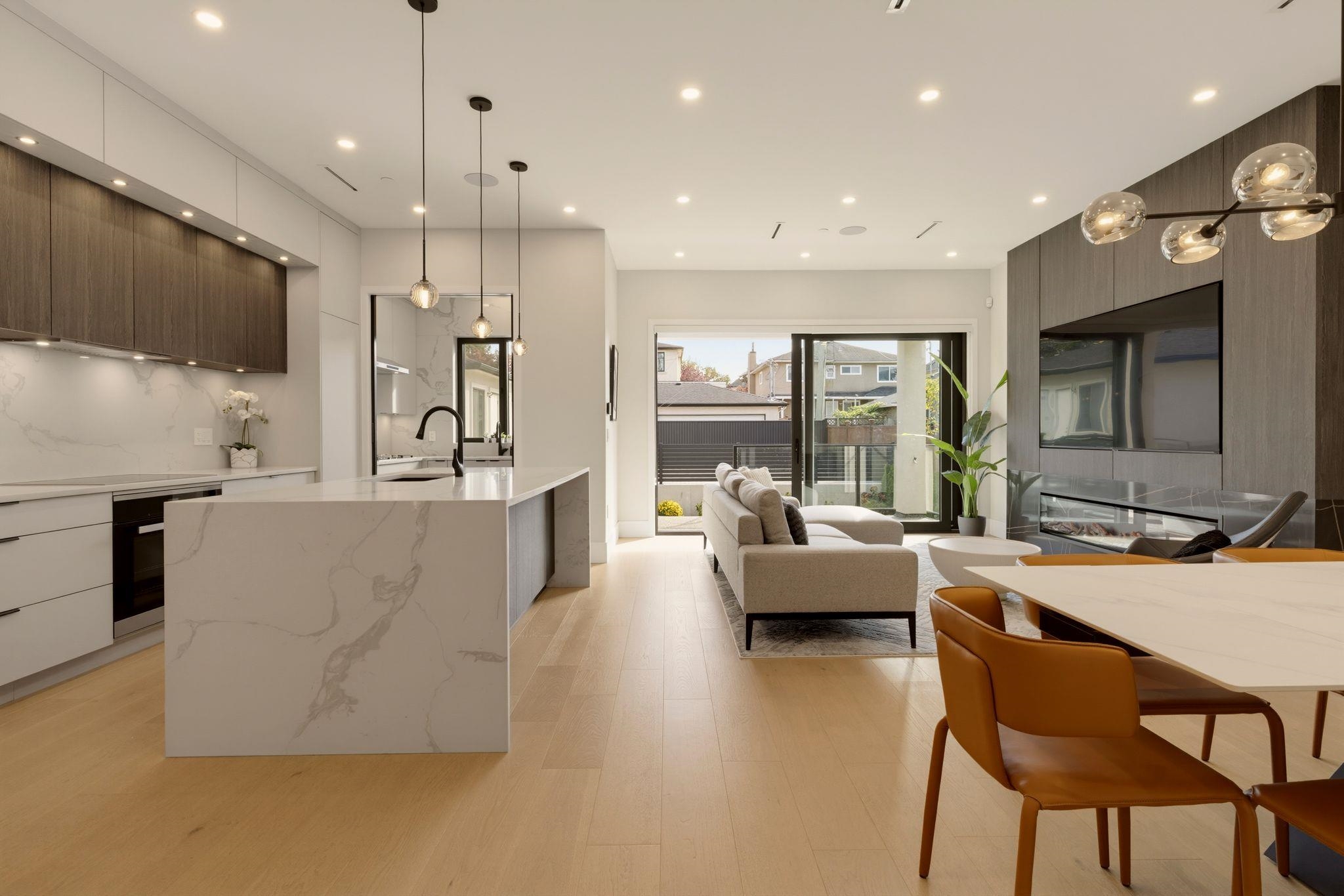 Open-plan kitchen and living room with a large stone island and sliding doors to the patio.