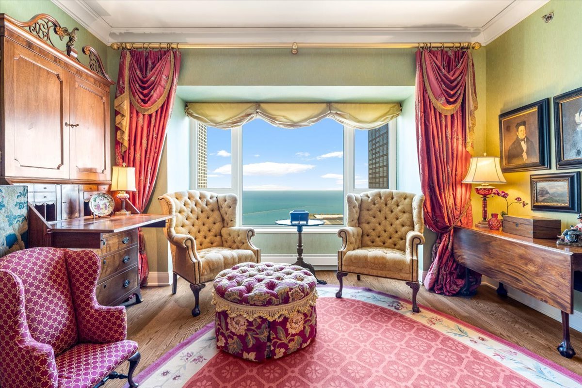 Sitting room with ornate furnishings and a broad Lake Michigan view through the window.