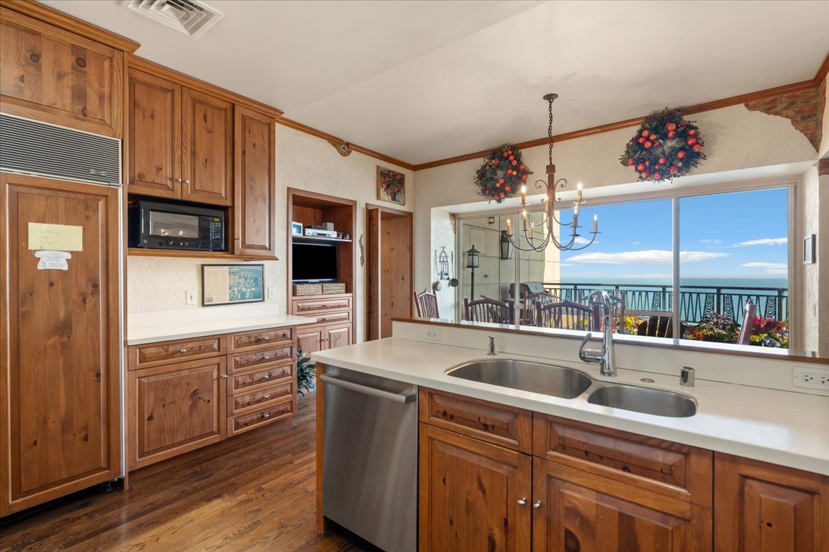 Kitchen with wood cabinetry, double-sink island, and sliding doors overlooking Lake Michigan.