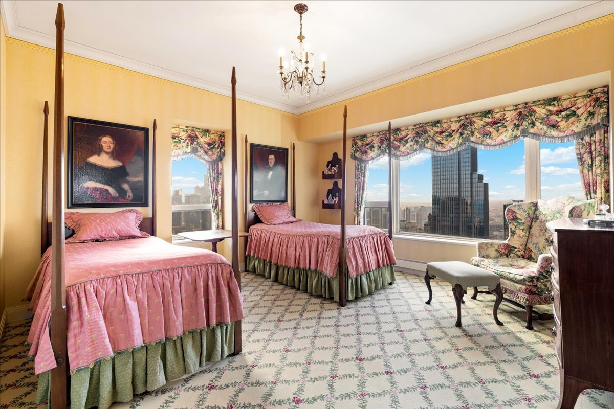 Bedroom with twin canopy beds and floral decor overlooking the Chicago skyline.