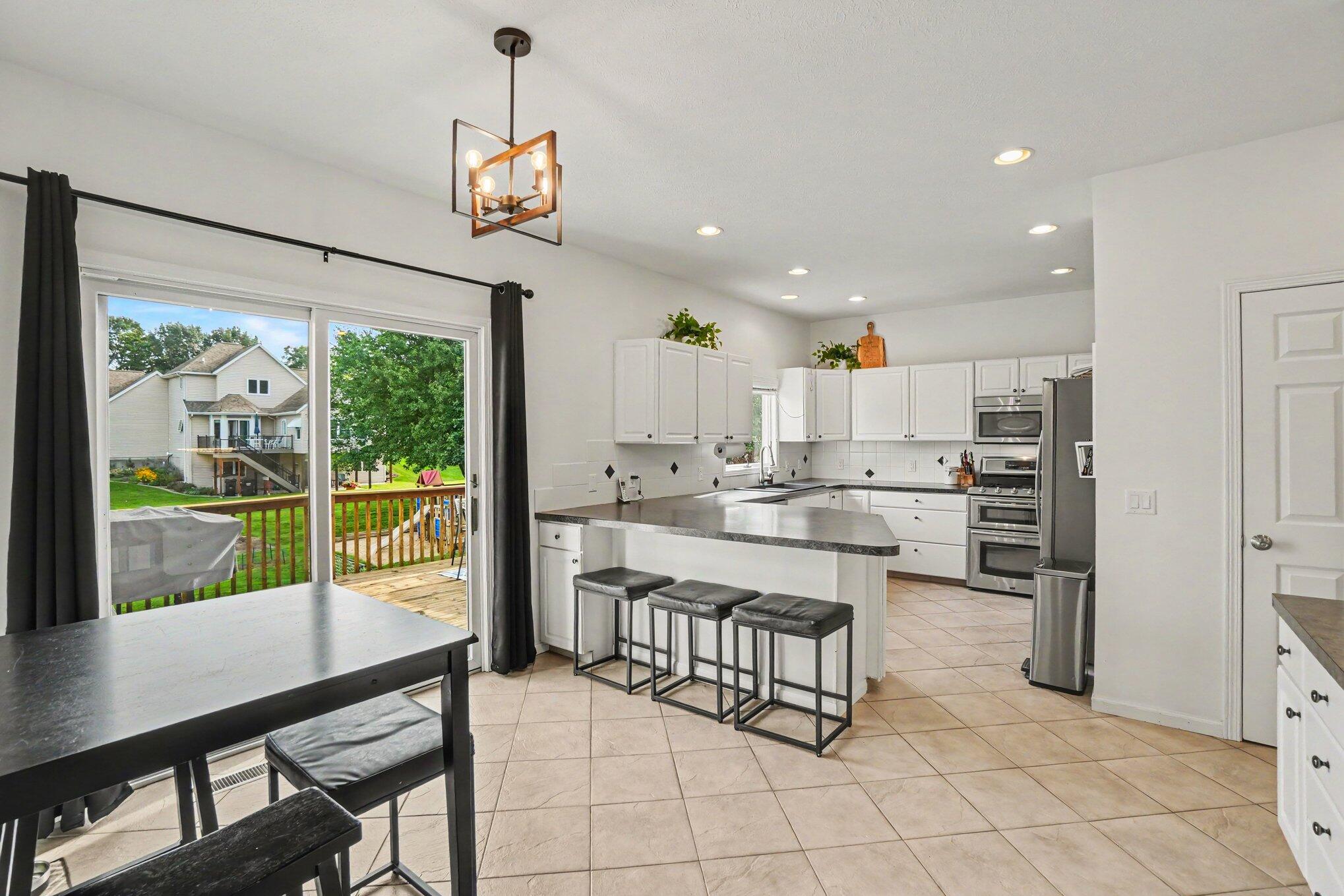 Kitchen with a large island, stainless appliances, and sliding doors to a deck