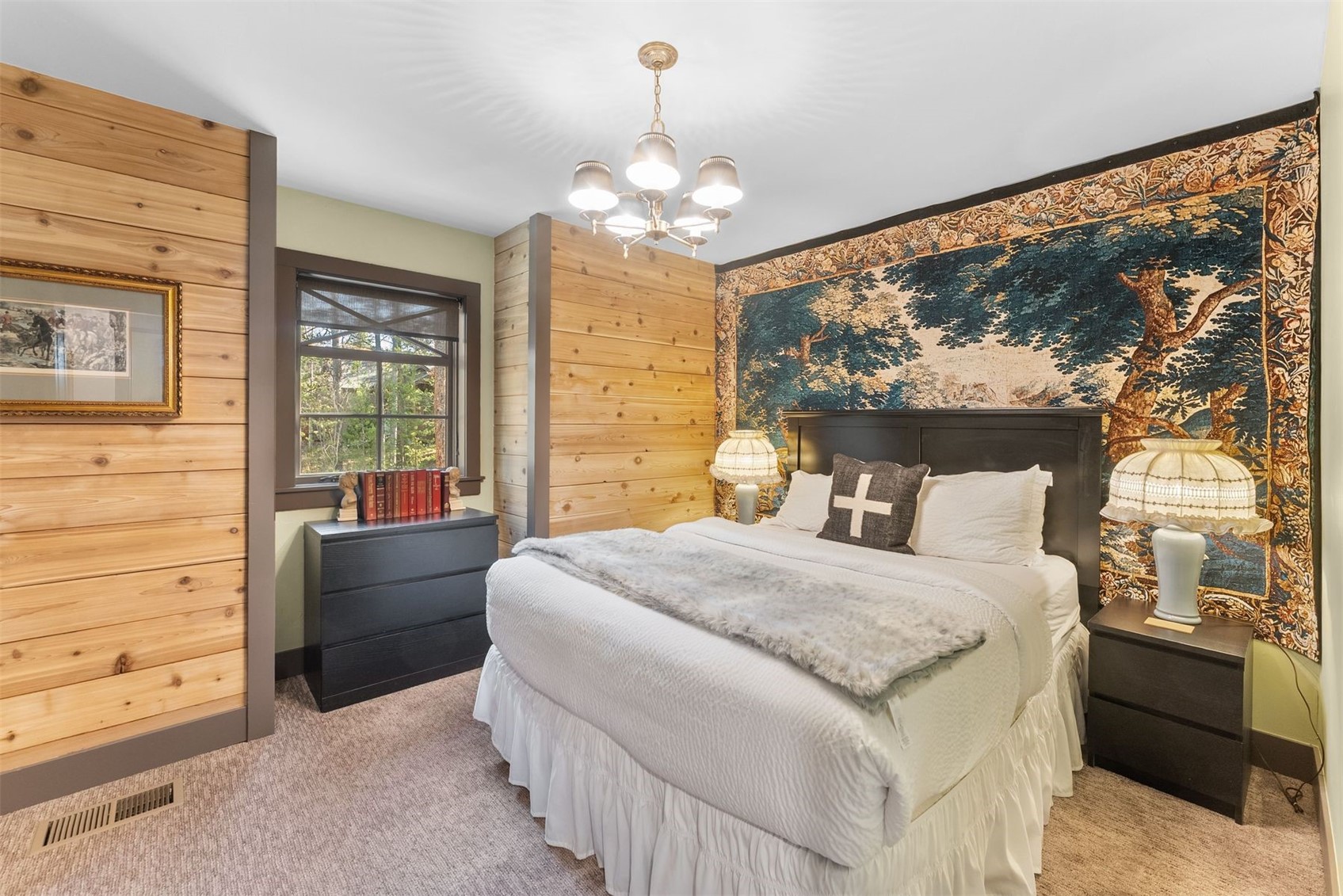 Bedroom with a white bed, warm wood-plank walls, and a large tapestry behind the headboard.