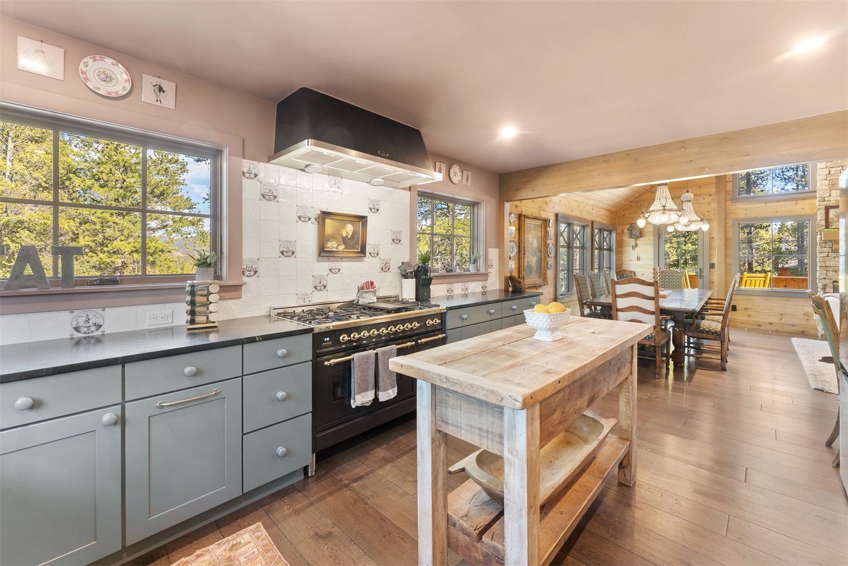 Kitchen with a rustic wood island, gray cabinets, and a dining room beyond.