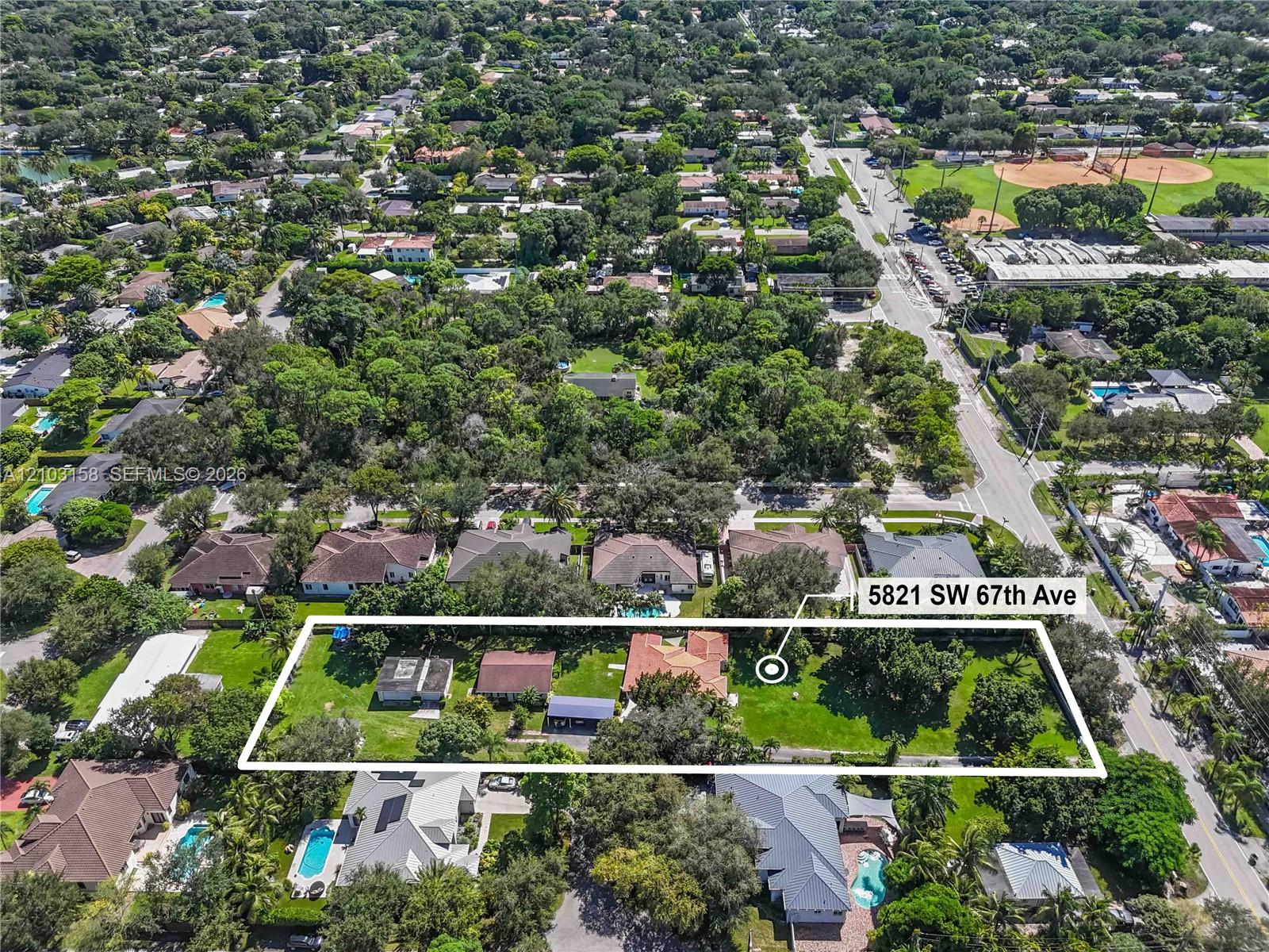 Aerial view of 5821 SW 67th Ave lot outlined among homes and trees.