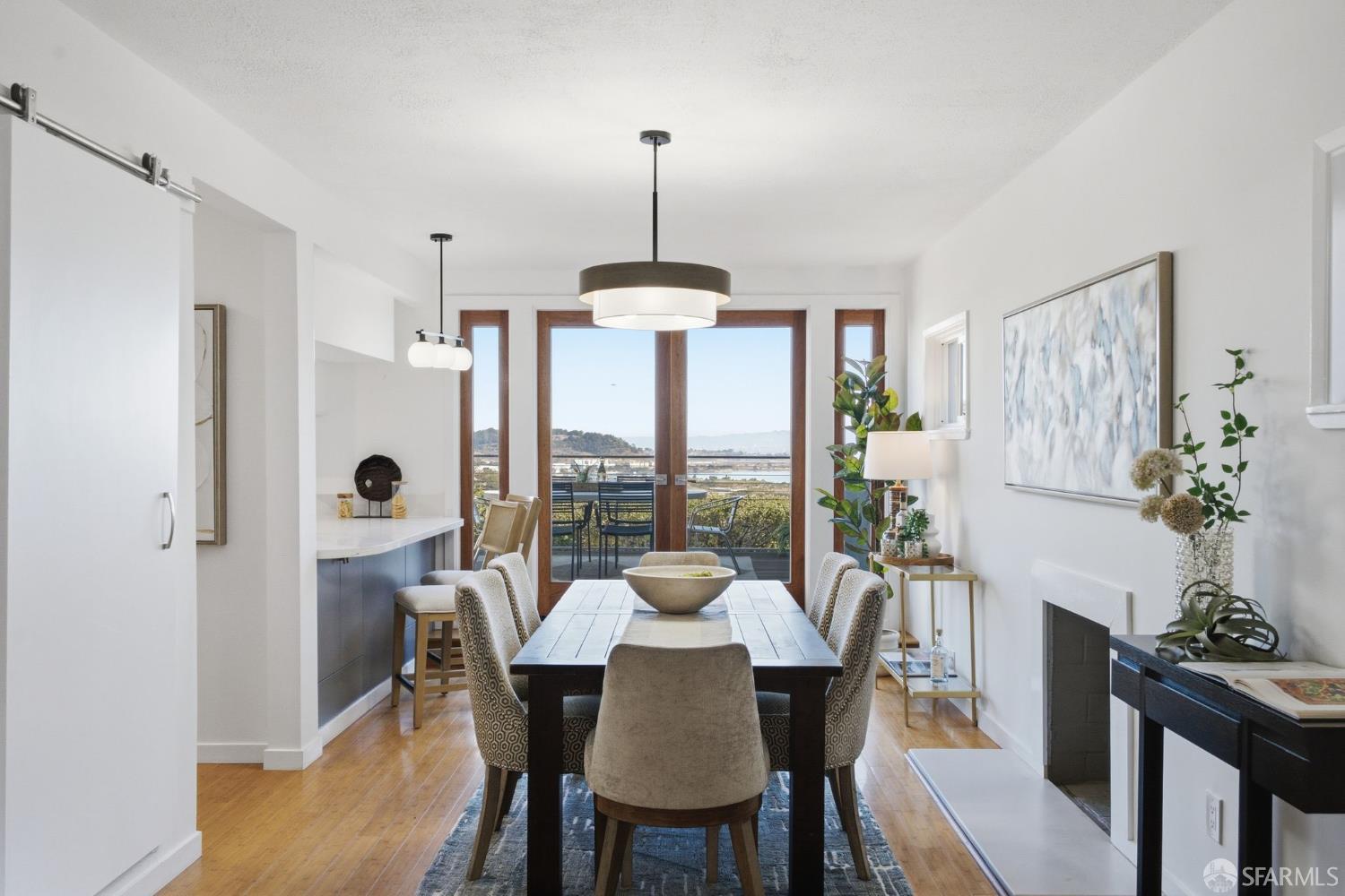 Dining room with a dark wood table and patio doors overlooking the water.
