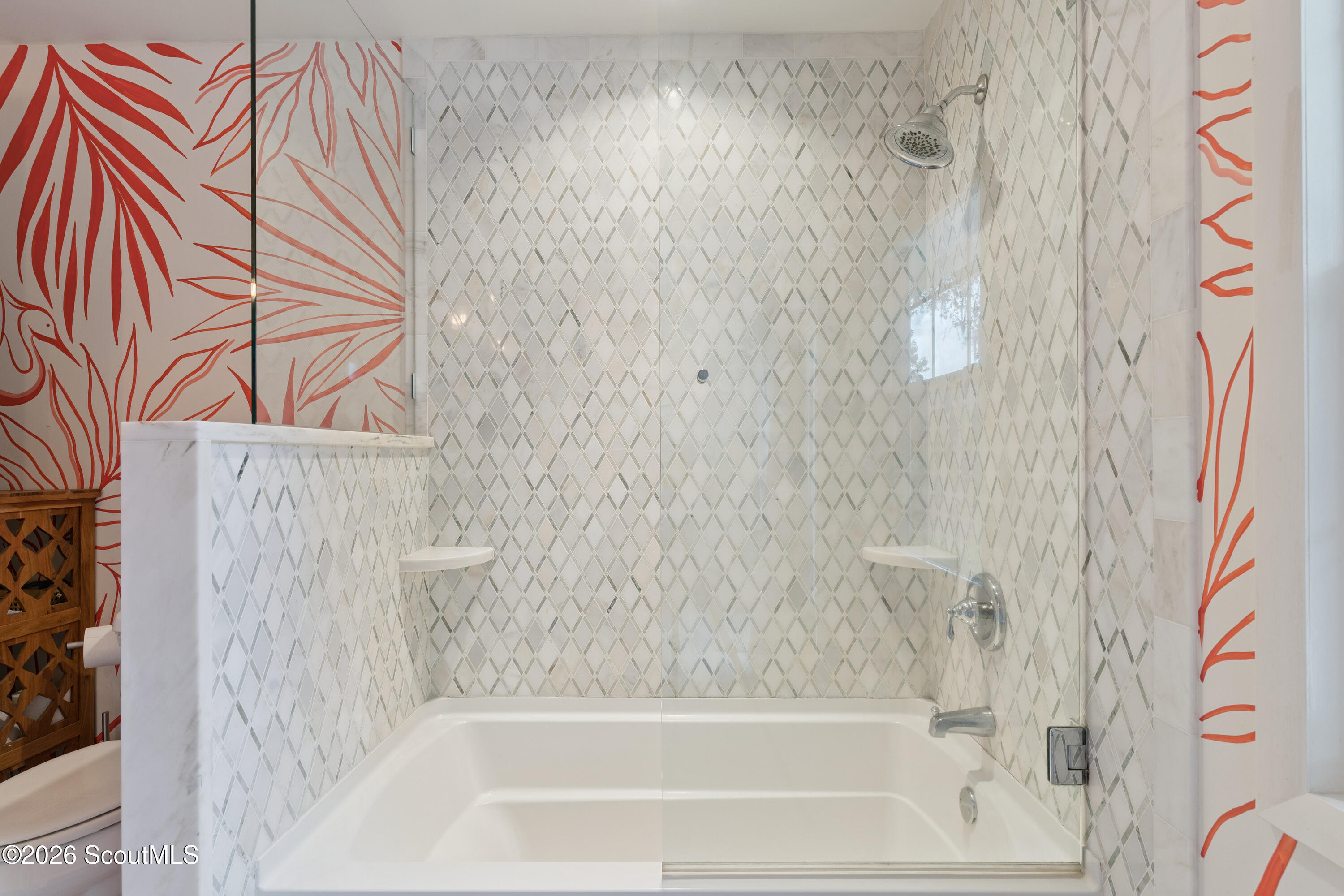 Bathroom with a glass-enclosed tub, diamond-pattern tile, and red botanical wallpaper.