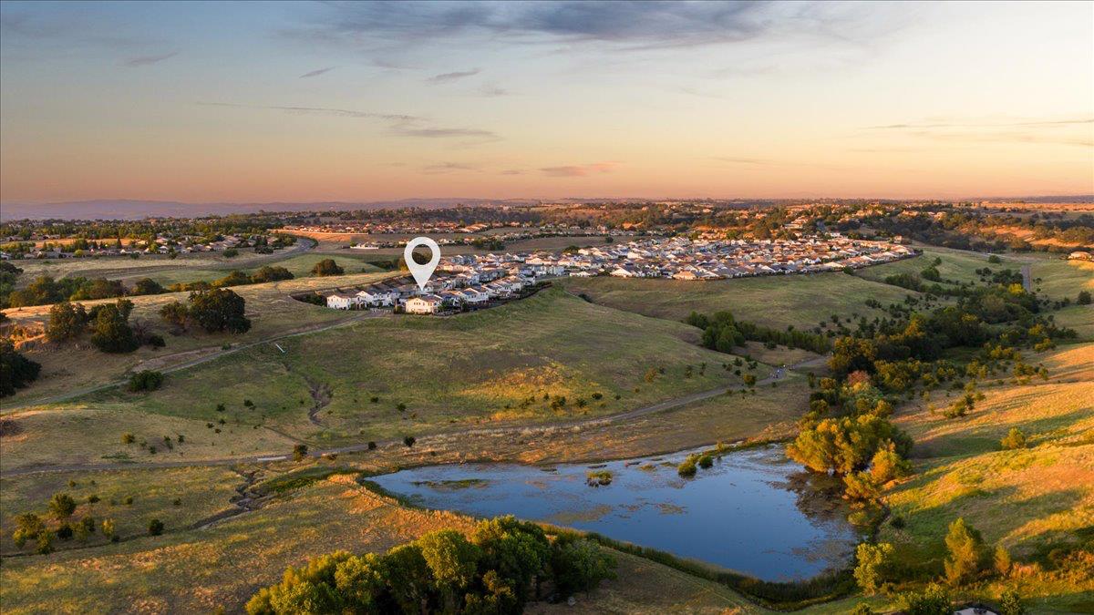 Aerial view of the neighborhood, with a location marker over the home and a pond in the foreground.